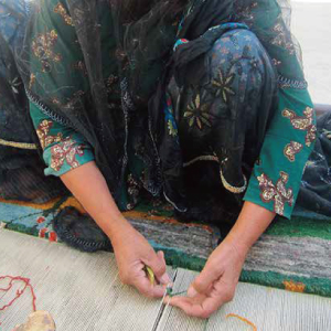 手作業で色糸を結ぶ